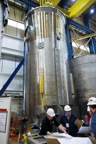 Team meeting in front of a Reactor Vessel Internals Core Barrel